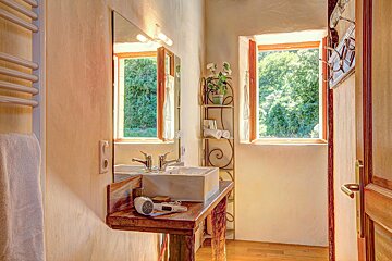 A bathroom with a sink and a mirror and a window
