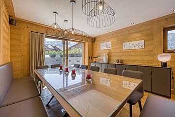 A dining room with a glass table and chairs