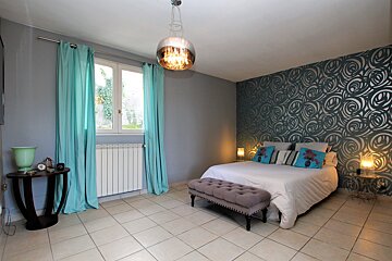 A bedroom with blue curtains and a bed