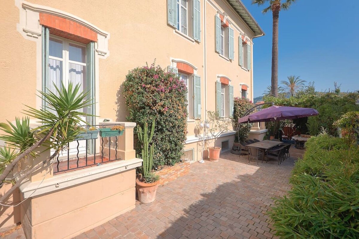 A patio with a table and chairs and a purple umbrella