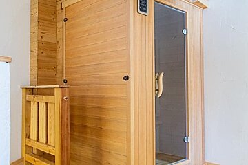 A wooden sauna with a digital display on the door