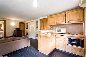 A kitchen with wooden cabinets and a microwave oven