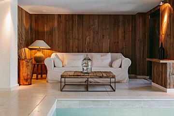 A living room with a white couch and a wooden table