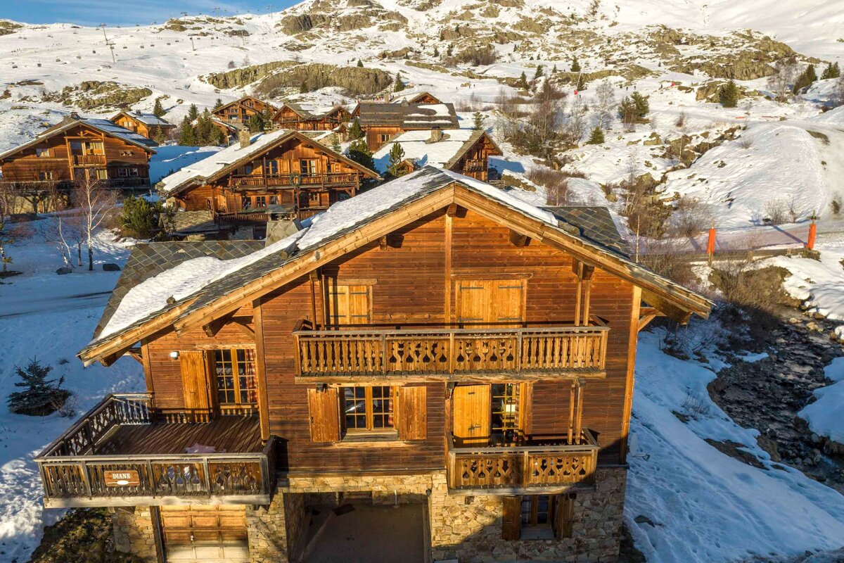 A large wooden house with a balcony in the snow
