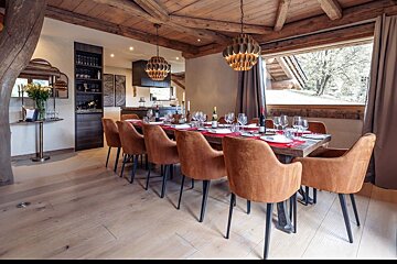 A dining room with a large table and chairs
