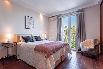 A bedroom with a bed and a chair with the word home on the wall