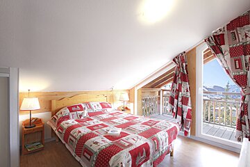 A bedroom with a bed with a red blanket that says ' eiffel tower ' on it