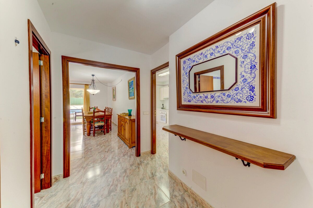 A hallway with a mirror and a wooden shelf