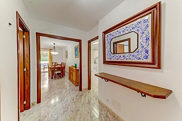 A hallway with a mirror and a wooden shelf