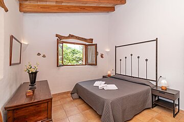 A bedroom with a large bed and a window