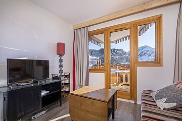 A living room with a flat screen tv and a wooden table