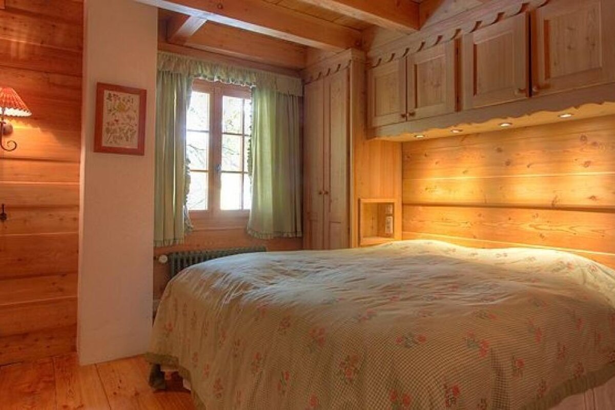 A bedroom with a bed , cabinets and a window