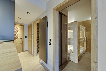 A hallway with bunk beds and a clock on the wall