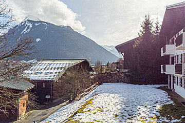 A snowy landscape with mountains in the background