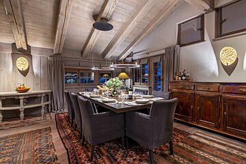 A dining room with a long table and chairs
