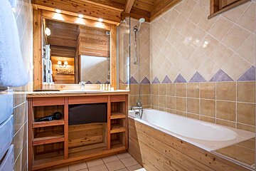 A bathroom with a bathtub a sink and a mirror