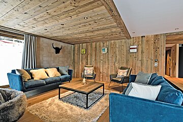 A living room with a blue couch and two chairs