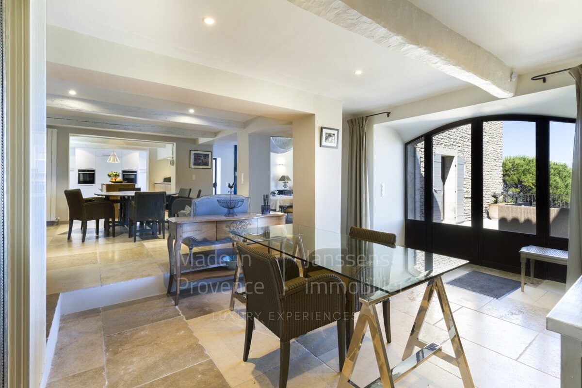 A dining room with a table and chairs and the words made in provence on the wall