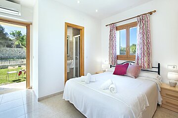 A bedroom with a large bed and pink curtains