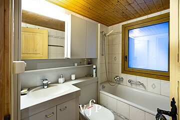 A bathroom with a window and a toilet with the letter p on it