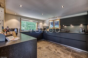 A kitchen with black cabinets and a large window