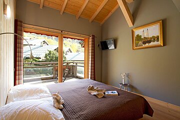 A bedroom with a painting on the wall above the bed