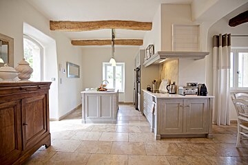 A kitchen with white cabinets and a stove top oven