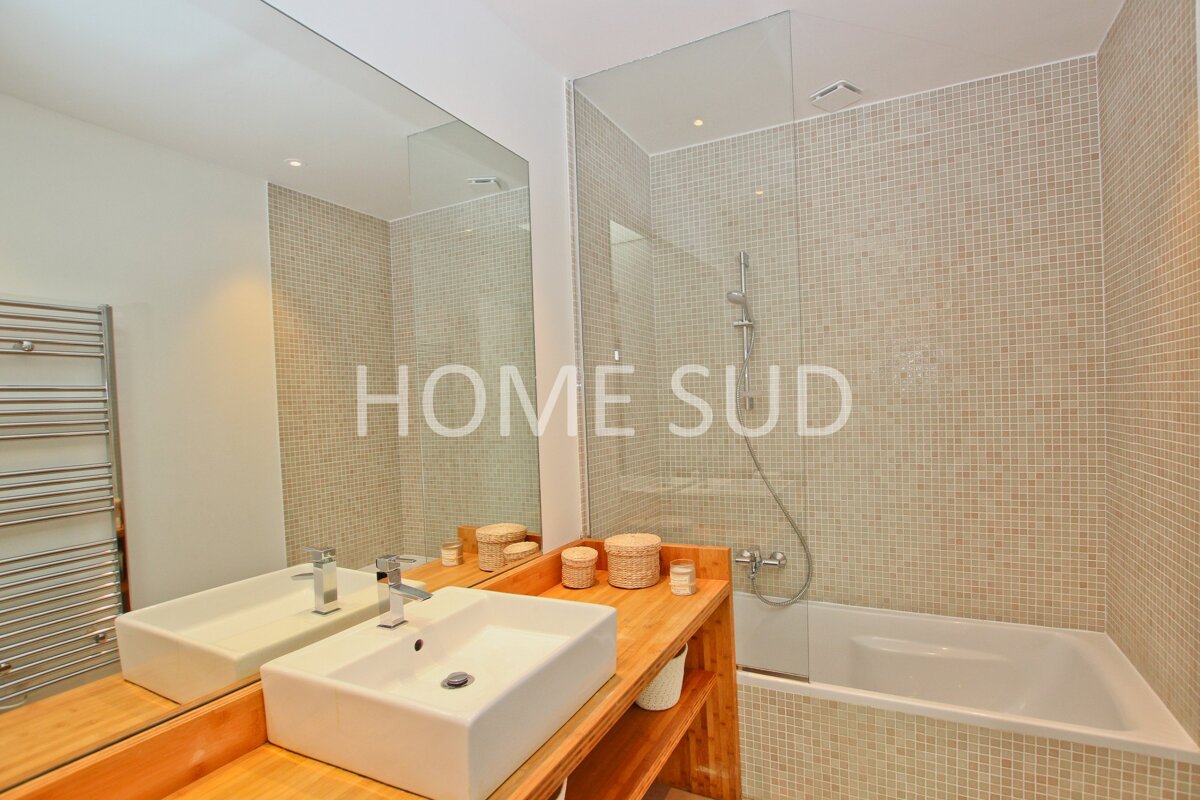 A bathroom with two sinks and a bathtub has home sud written on the wall