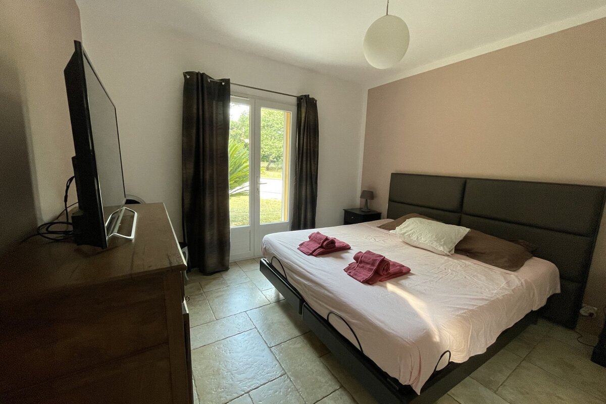 A bedroom with a large bed and a flat screen tv