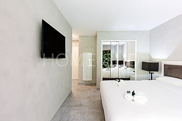 A hotel room with a bed and a flat screen tv