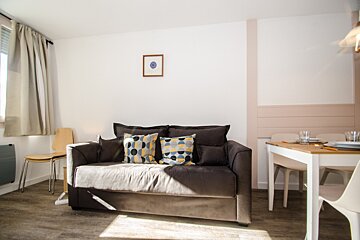 A living room with a couch and a table and chairs