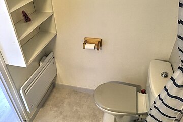 A bathroom with a toilet and a shower curtain