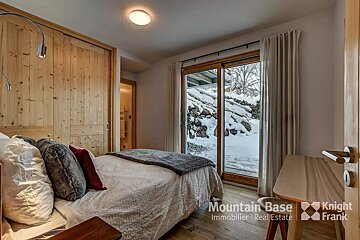A bedroom with a bed and a desk from mountain base immobilier real estate