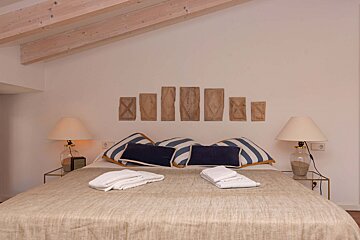 A bed with blue and white pillows and lamps