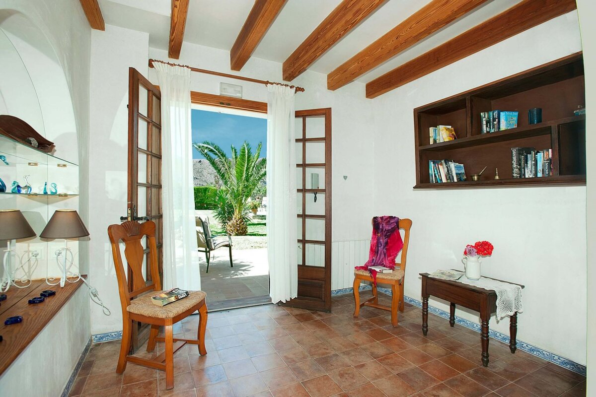 A room with a chair and a bookshelf with books on it