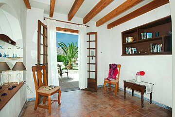 A room with a chair and a bookshelf with books on it