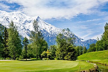 A golf course with a snowy mountain in the background