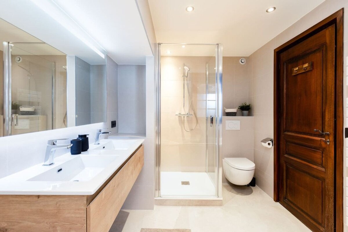A bathroom with two sinks a toilet and a shower
