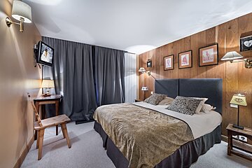 A hotel room with a king size bed and a tv