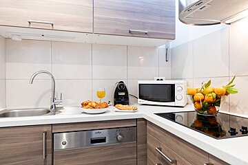 A kitchen with a stainless steel dishwasher and a microwave