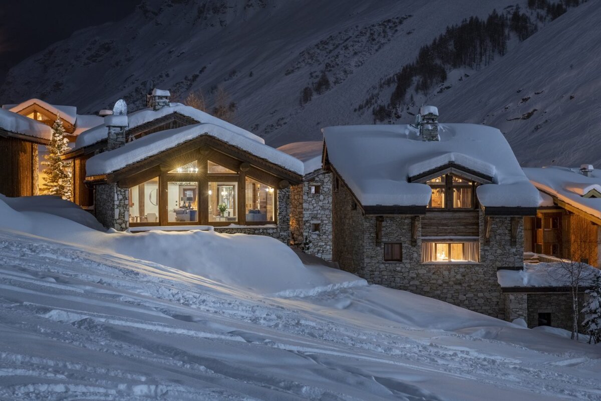 A snowy mountainside with a house in the foreground