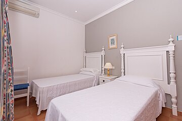 A bedroom with two beds and a picture on the wall