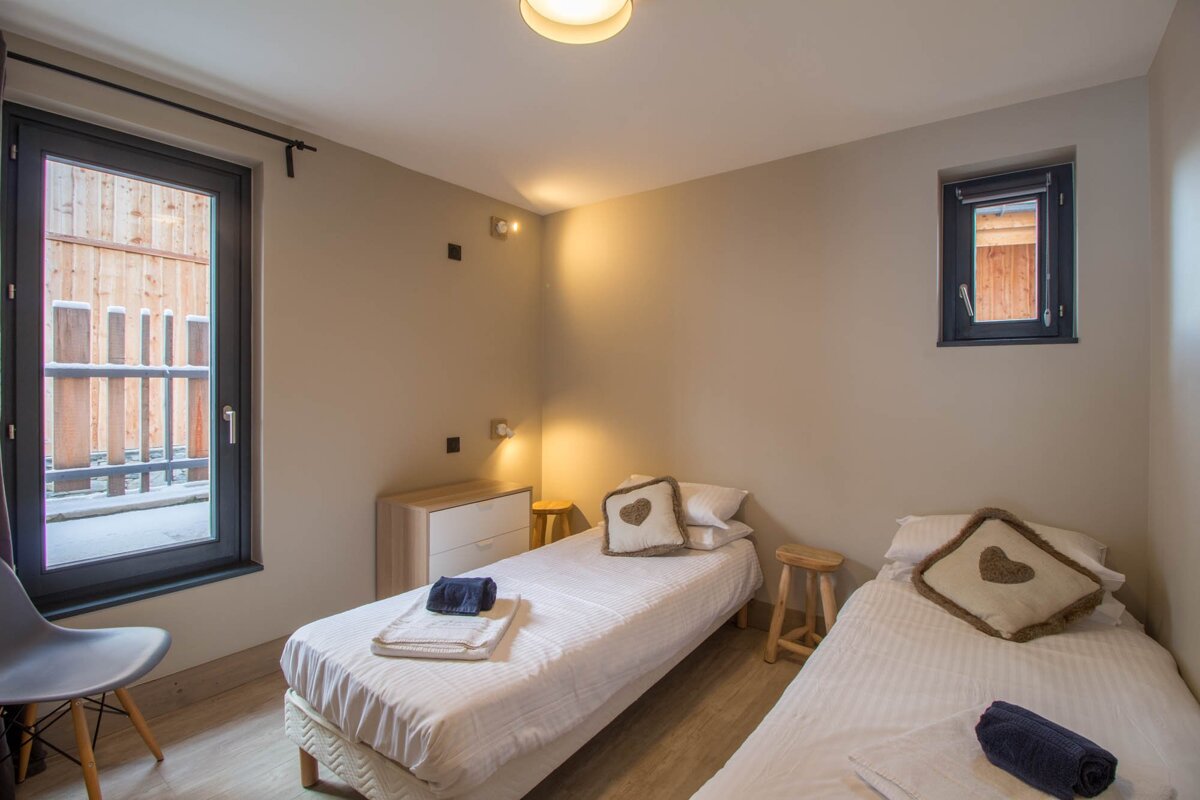 A bedroom with two beds and a window