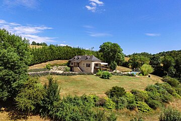 A house sits in the middle of a lush green field