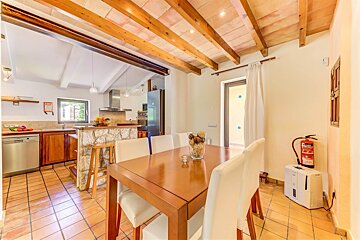 A kitchen with a table and chairs and a fire extinguisher