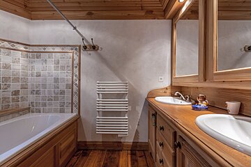 A wooden bedroom with a bed and two lamps