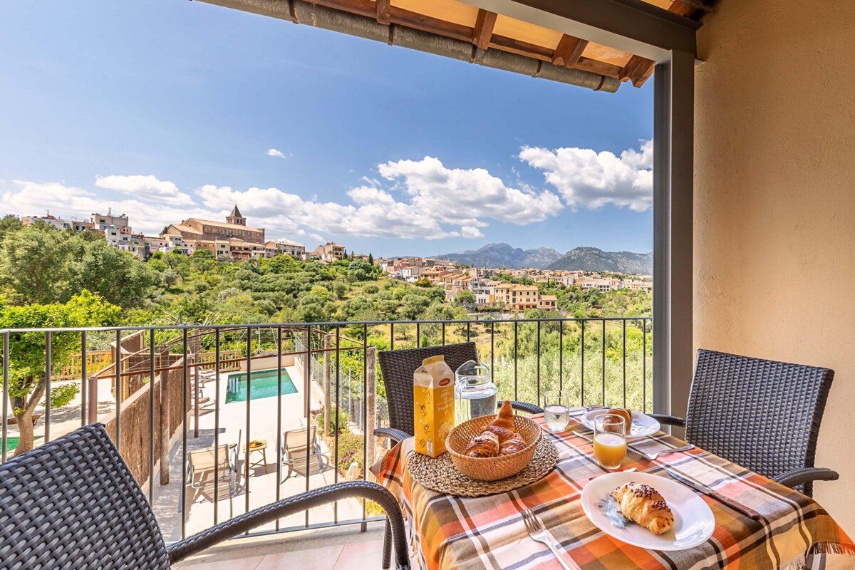 A balcony with a view of a city and mountains