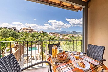 A balcony with a view of a city and mountains