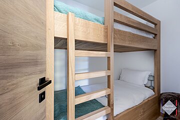 A bunk bed with a rental designer logo in the corner