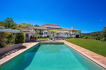 A large swimming pool in front of a house that says made in provence